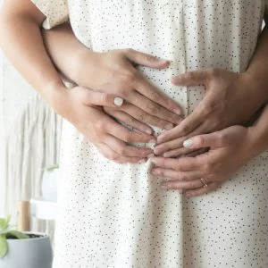 Casal com a mão na barriga no início da gestação - DNA gestacional não invasivo