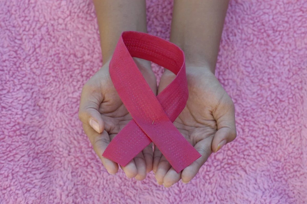 Mãos com laço rosa - Painel de câncer de mama e ovário hereditário